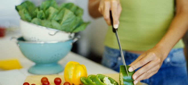 mid section view of a woman cutting vegetables